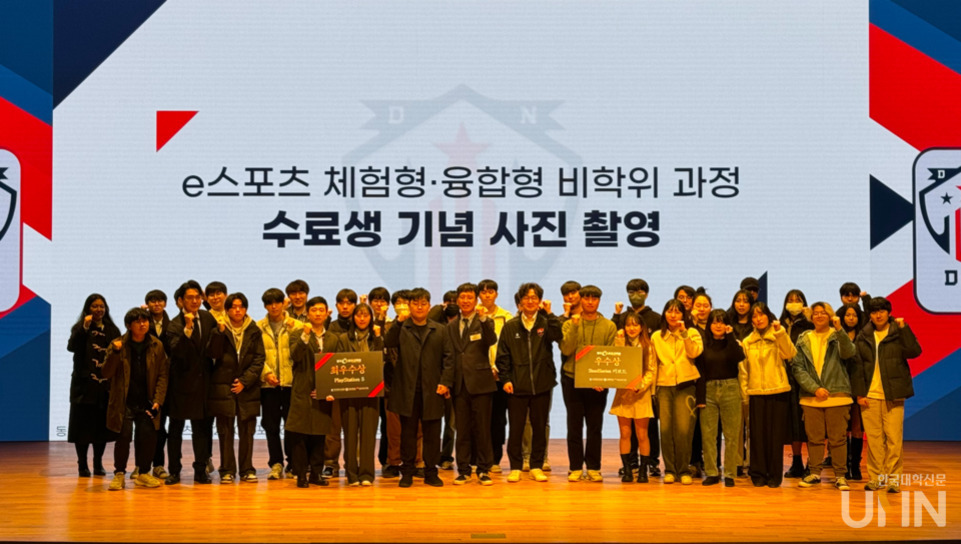 e스포츠 체험형·융합형 비학위 과정 수료생 기념 사진 촬영 행사에서 단체로 무대에 모여 있는 여러 명의 학생들