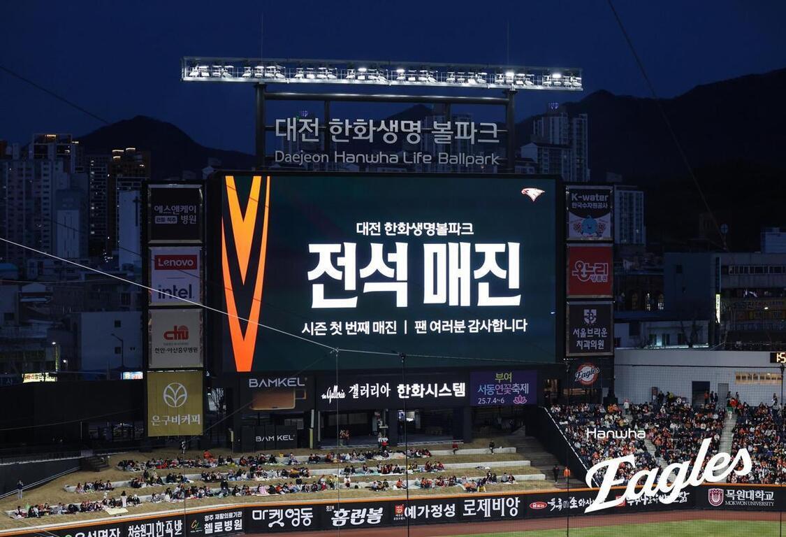야구장 전광판에 '전석 매진'이라는 문구가 크게 표시되어 있고, 많은 관중이 경기장을 채우고 있다. 상단에는 '대전 한화생명 불파크'라는 표지판이 보인다.