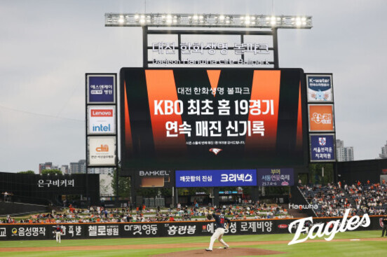 대전 한화생명 이글스 파크 전광판에 'KBO 최초 홈 19경기 연속 매진 신기록'이라는 문구가 크게 표시되어 있고, 야구 경기가 진행 중인 모습.