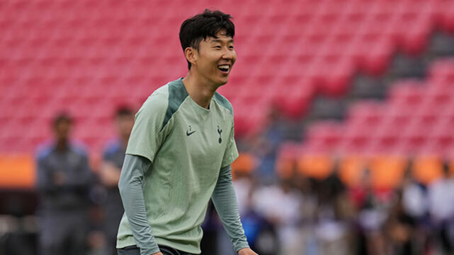 축구장에서 연습복을 입고 웃고 있는 남성 선수의 모습