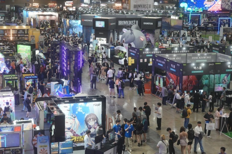 대형 게임 박람회장에서 여러 부스와 많은 사람들이 전시를 관람하고 있는 모습