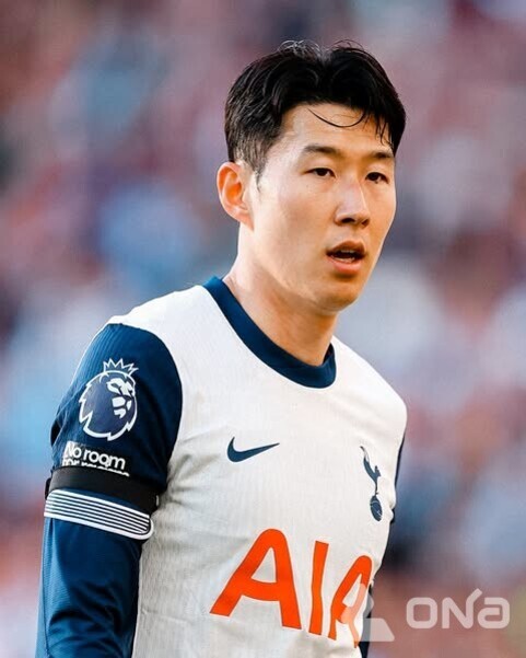 축구 유니폼을 입은 남성 선수가 경기장에서 서 있는 모습