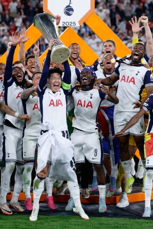 축구 경기 후 토트넘 홋스퍼 선수들이 트로피를 들고 환호하며 우승을 기념하는 모습