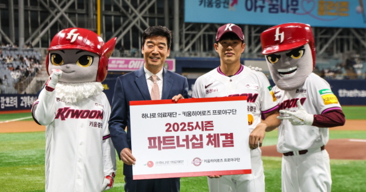야구장 그라운드에서 키움 히어로즈 유니폼을 입은 두 마스코트, 정장을 입은 남성, 야구선수가 함께 '2025시즌 파트너십 체결'이라고 적힌 팻말을 들고 기념 촬영을 하고 있다.