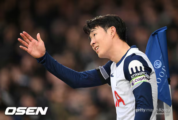 축구 경기 중 코너킥 지점 근처에서 팔을 들어 올리고 있는 축구 선수의 모습