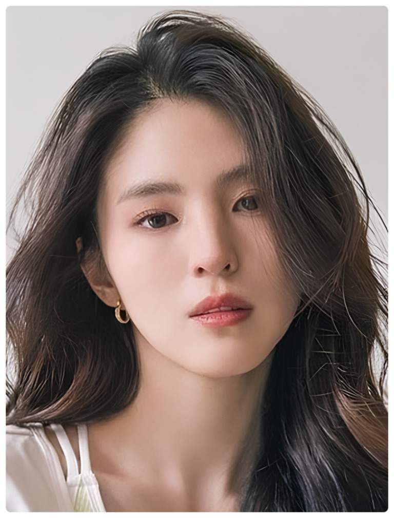 긴 머리를 가진 젊은 여성이 정면을 응시하고 있는 인물 사진