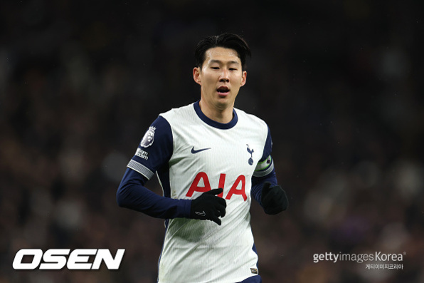축구 경기 중 토트넘 홋스퍼 유니폼을 입고 뛰고 있는 남자 선수의 모습