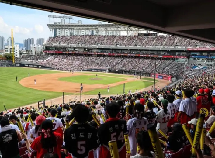 야구 경기장에서 많은 관중들이 경기를 응원하며 관람하고 있는 모습