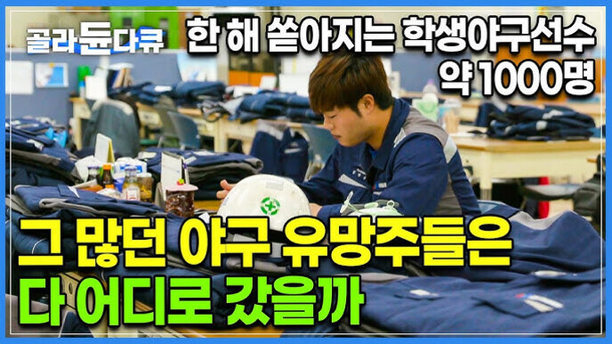 작업복을 입은 남성이 책상에 앉아 일하는 모습. 주변에는 작업복과 안전모 등이 놓여 있다. 화면 상단에는 '골라듀다큐 한 해 쏟아지는 학생야구선수 약 1000명', 하단에는 '그 많던 야구 유망주들은 다 어디로 갔을까'라는 문구가 적혀 있다.
