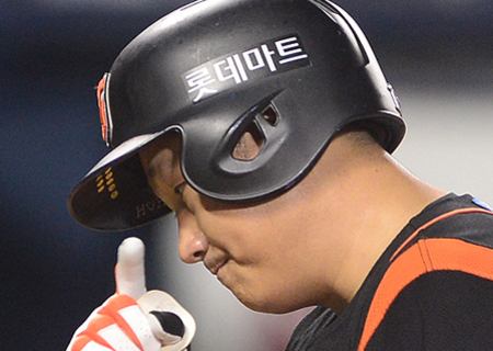 야구 헬멧을 쓴 선수가 손가락을 들어올리고 있는 모습