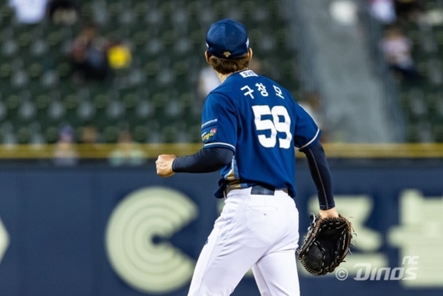 파란색 유니폼을 입고 등번호 59번이 적힌 야구 선수가 경기장에서 글러브를 낀 채 서 있는 모습