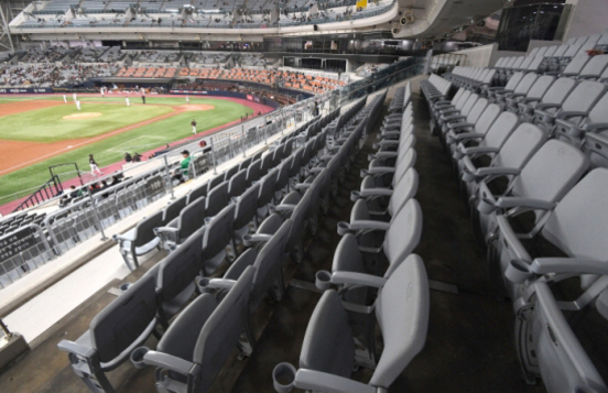 야구장 내 관중석이 비어 있고, 경기장은 멀리에서 경기가 진행 중인 모습