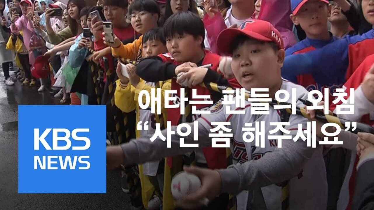 야구 팬들이 경기장 앞에서 선수에게 사인을 받으려고 야구공을 내밀고 있다. 화면 왼쪽에 'KBS NEWS' 로고가 있고, 중앙에는 '애타는 팬들의 외침 사인 좀 해주세요'라는 자막이 있다.