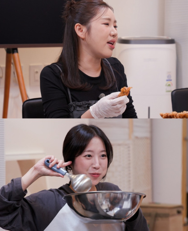 두 명의 여성이 주방에서 요리하거나 음식을 먹고 있는 모습. 한 여성은 장갑을 끼고 치킨 조각을 들고 있고, 다른 여성은 큰 볼과 국자를 들고 있다.