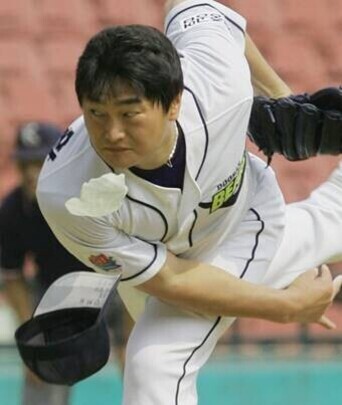 야구 선수가 공을 던지는 순간 모자가 벗겨지고 있다.